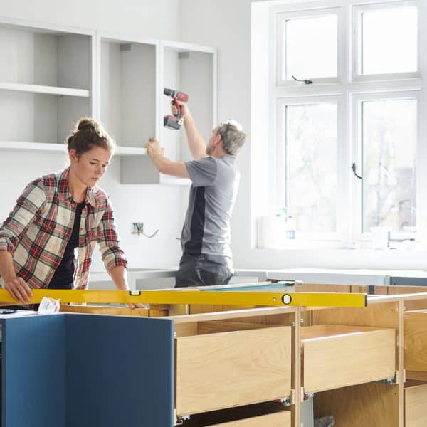 a female kitchen fitting cupboards for worktop